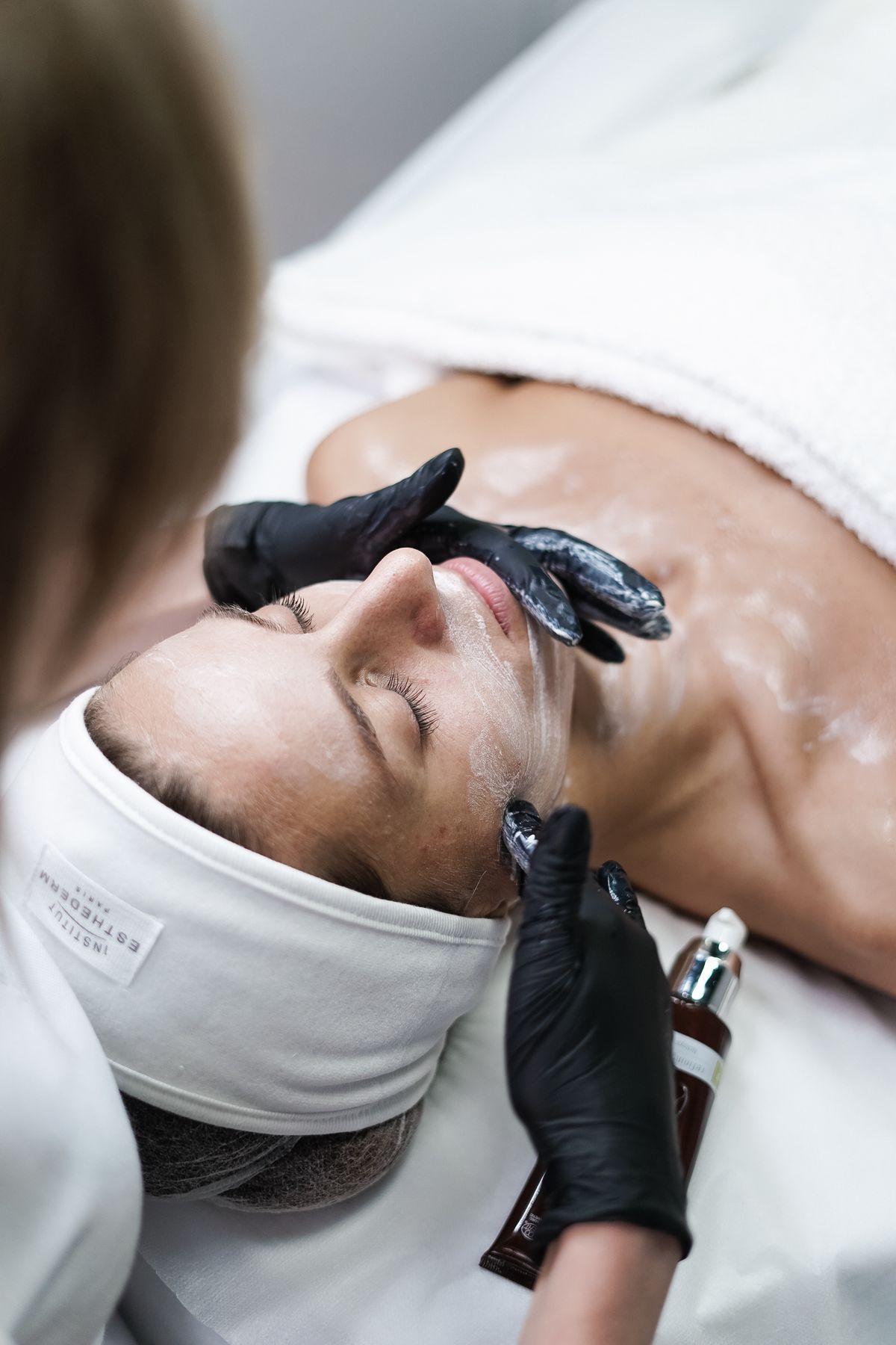 Facial treatment with a clay mask being removed