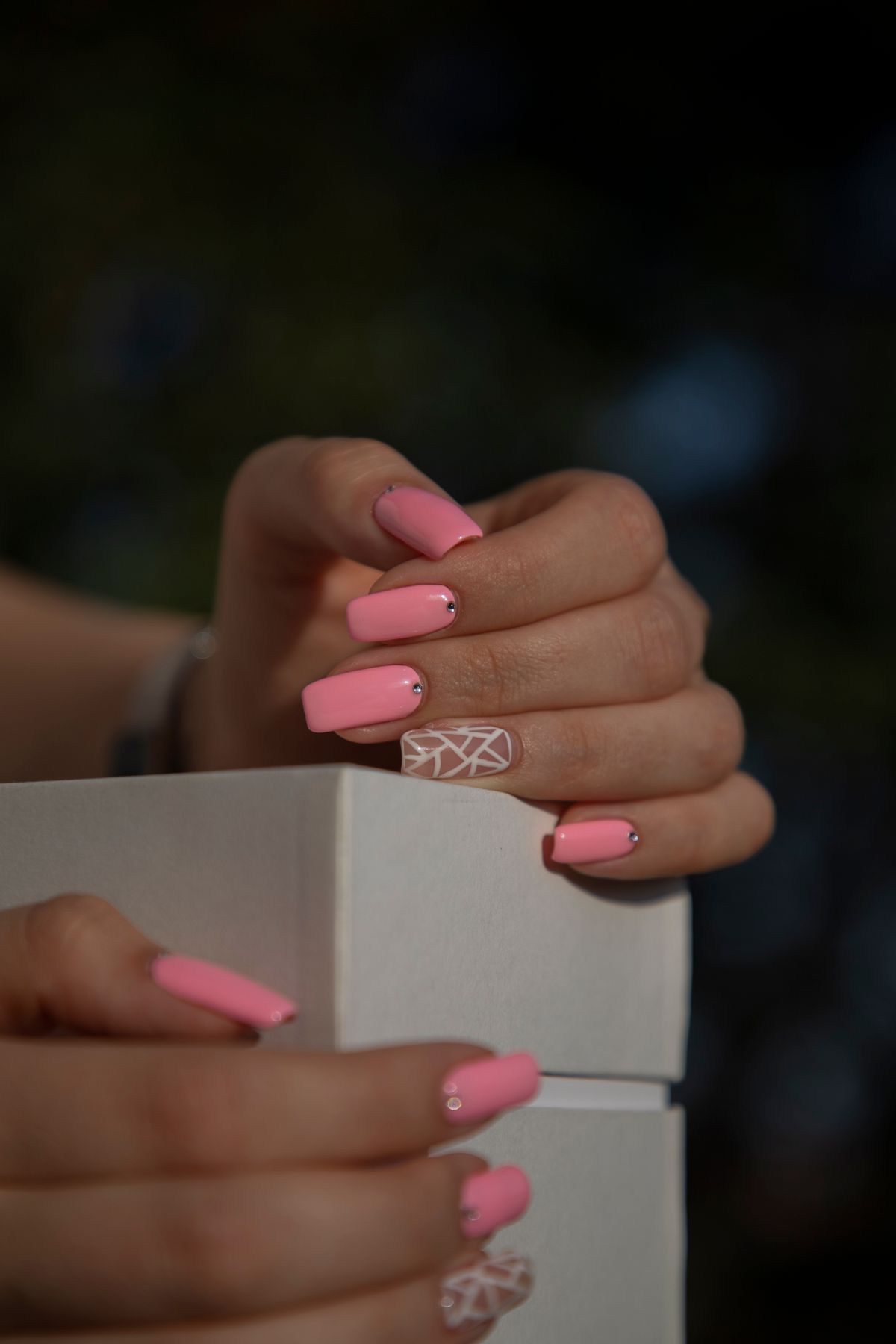 Detailed nail art with a polished pink finish