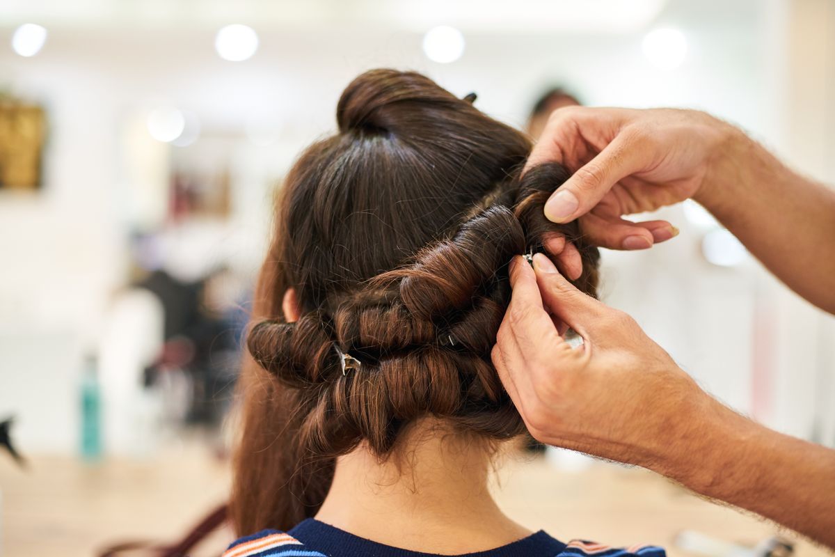 Hair styling in progress, an updo being pinned into place